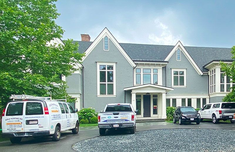 A large house with a lot of cars parked in front of it