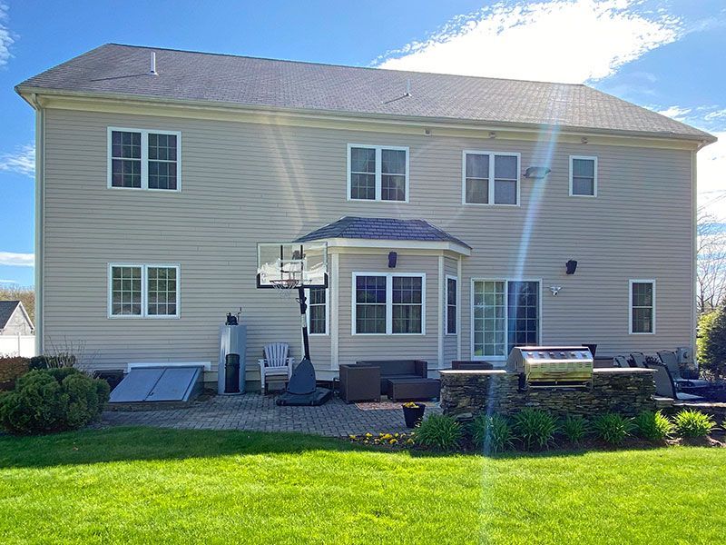 A large house with a basketball hoop in the backyard.