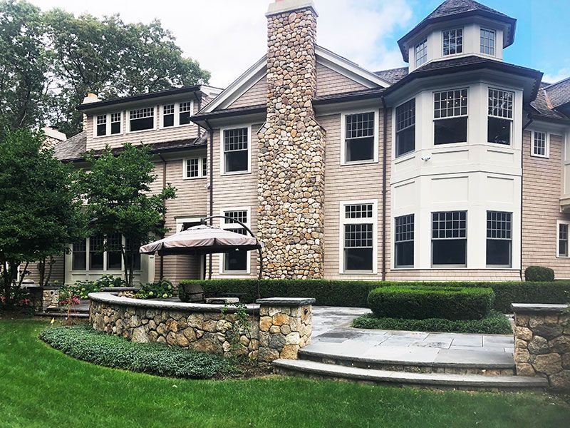 A large house with a stone chimney and many windows
