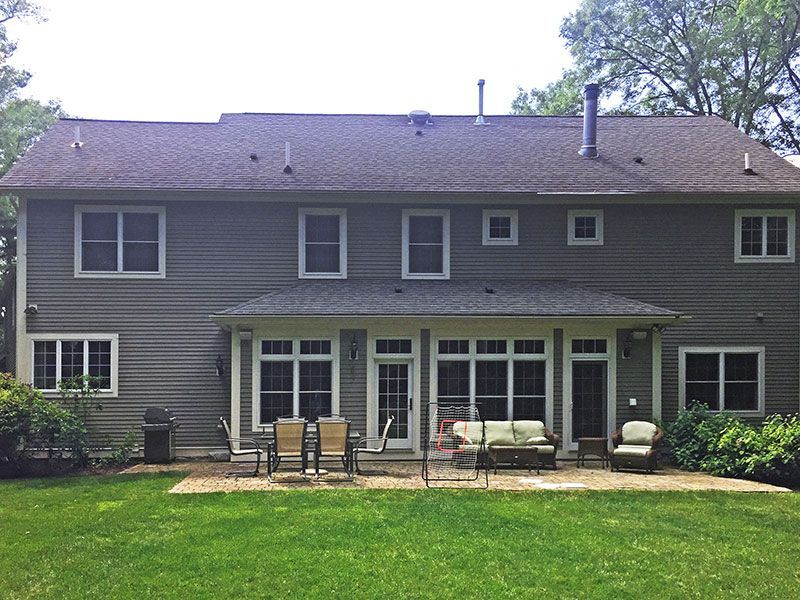 The back of a large house with a large lawn in front of it