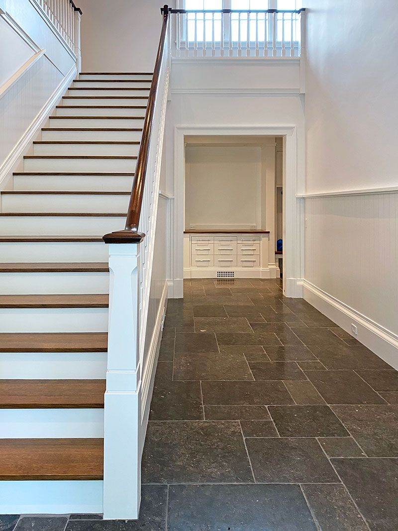 A hallway with stairs leading up to the second floor
