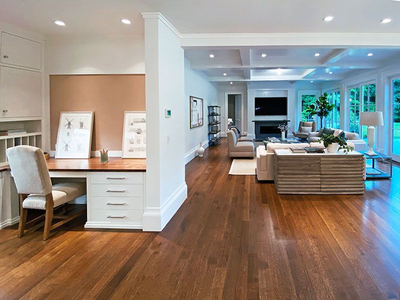 A living room with hardwood floors and a desk.