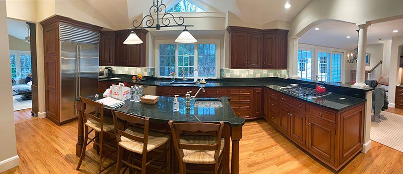 A kitchen with a large island , stainless steel appliances and wooden cabinets.