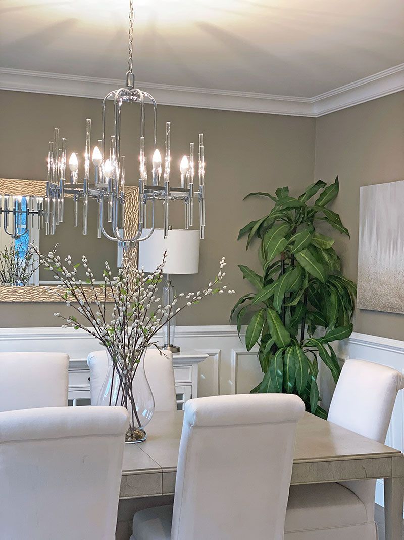 A dining room with a table and chairs and a chandelier