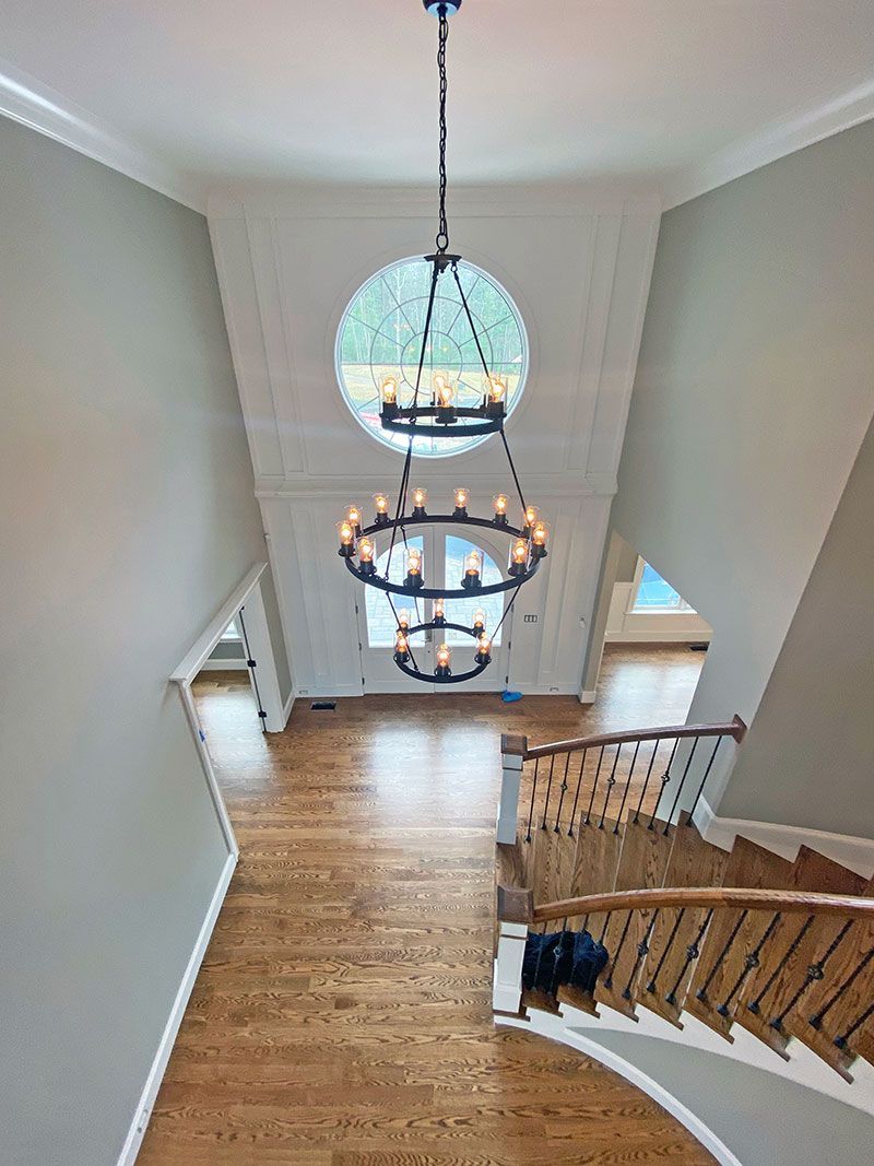 An aerial view of a staircase with a chandelier hanging from the ceiling.