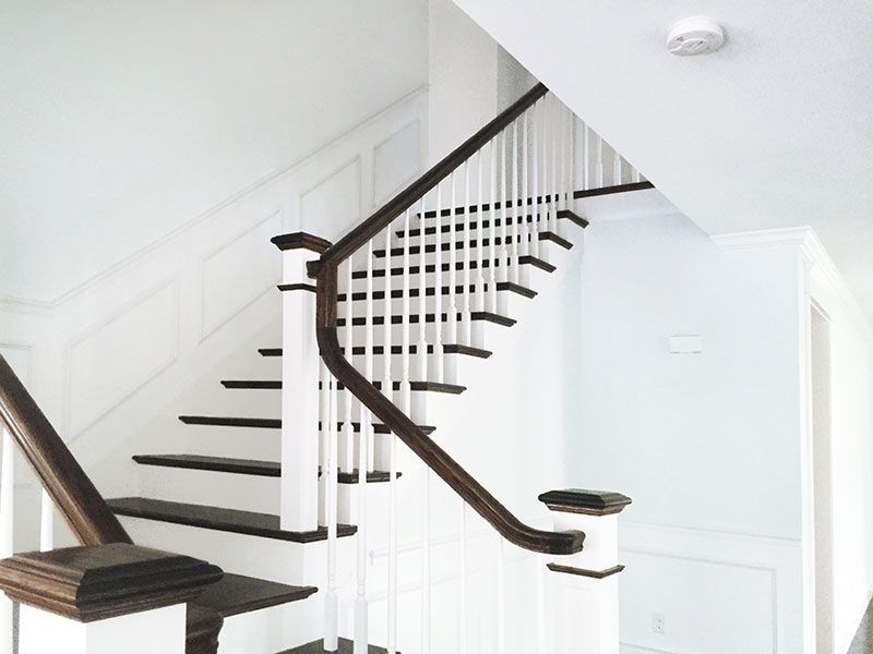A staircase with a white railing and black steps