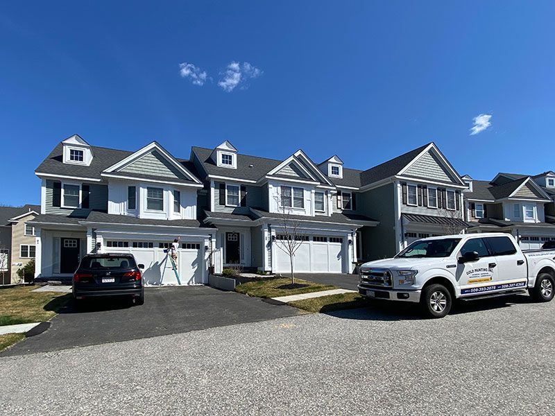 A row of houses with trucks parked in front of them.