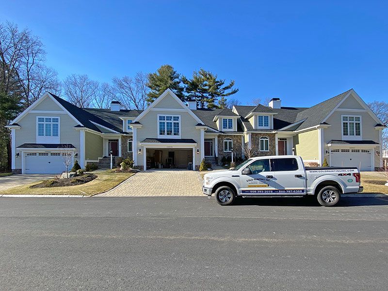 A white truck is parked in front of a large house.
