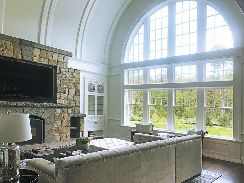 A living room with a lot of windows and a fireplace