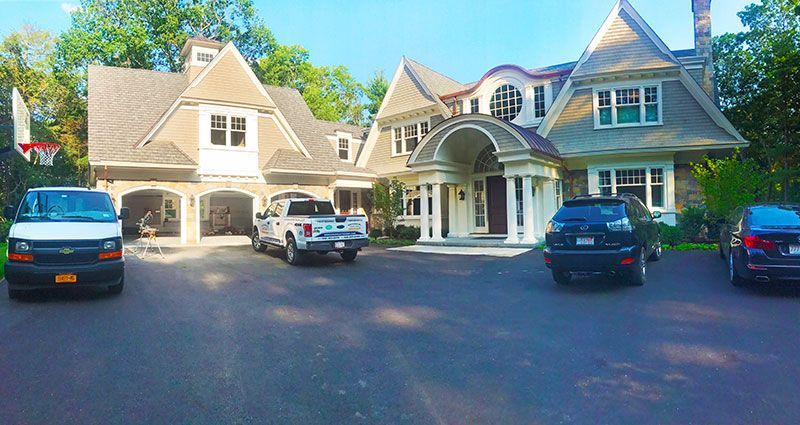 A large house with cars parked in front of it.