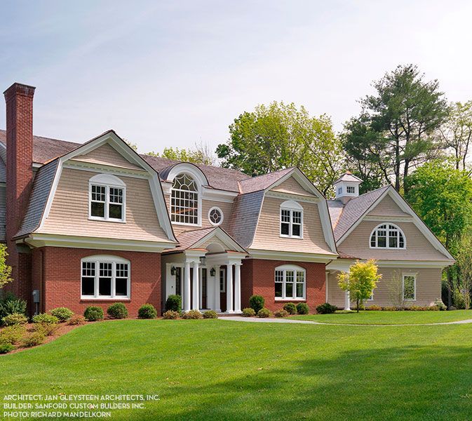 A large brick house with a large lawn in front of it