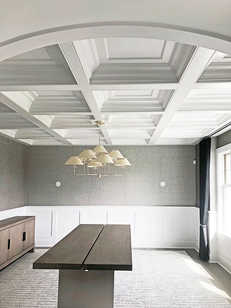 A dining room with a table and a chandelier hanging from the ceiling.