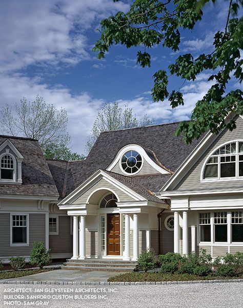 A large house with a gray roof and a round window