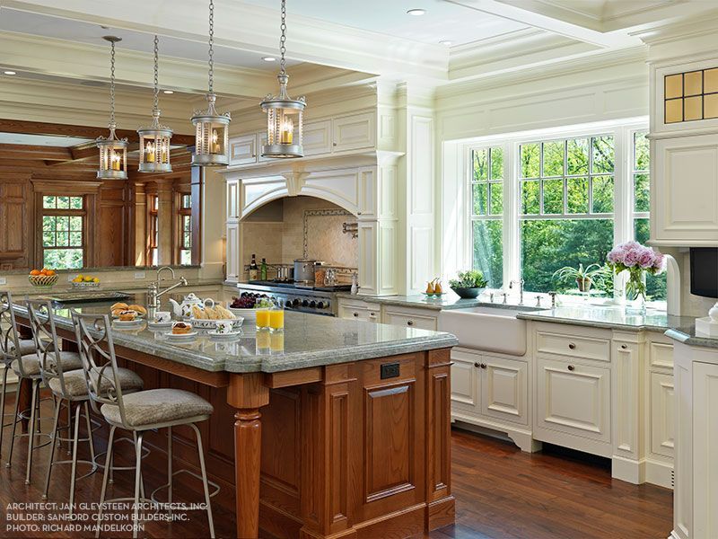 A kitchen with white cabinets and a large island in the middle
