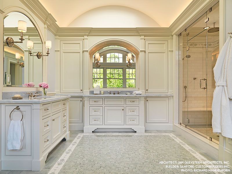 A bathroom with two sinks and a walk in shower.