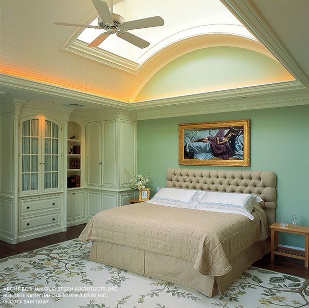 A bedroom with a large bed and a ceiling fan
