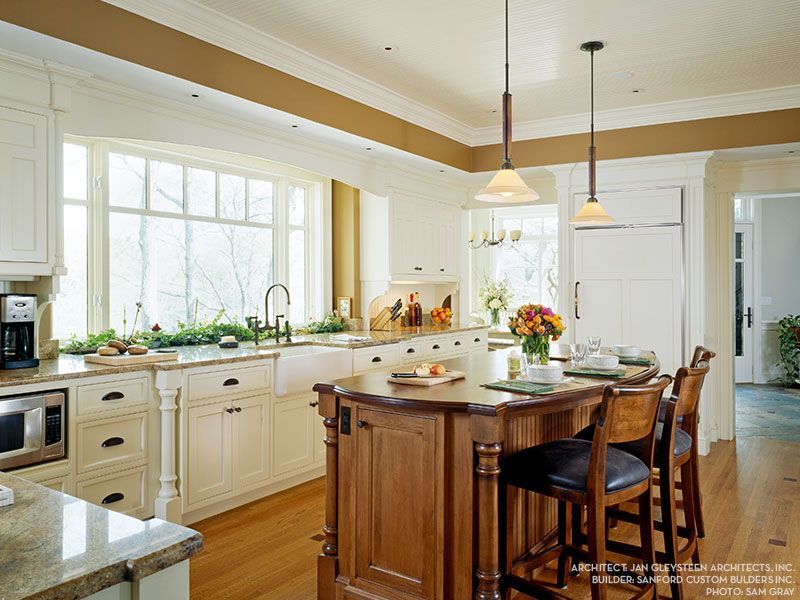 A kitchen with white cabinets and a large island in the middle