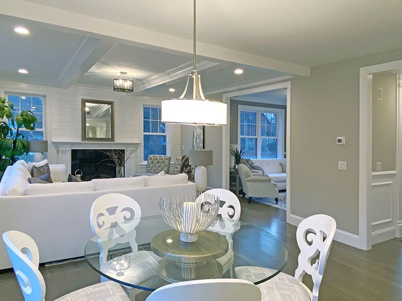 A living room with a glass dining table and chairs