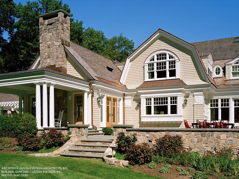 A large house with a porch and stairs leading up to it