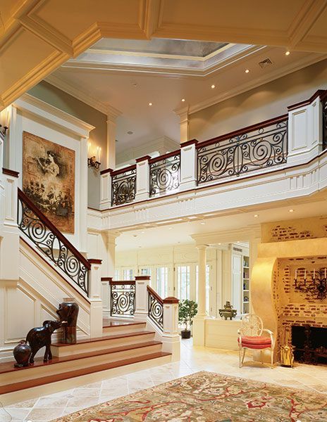A living room with a staircase and a rug