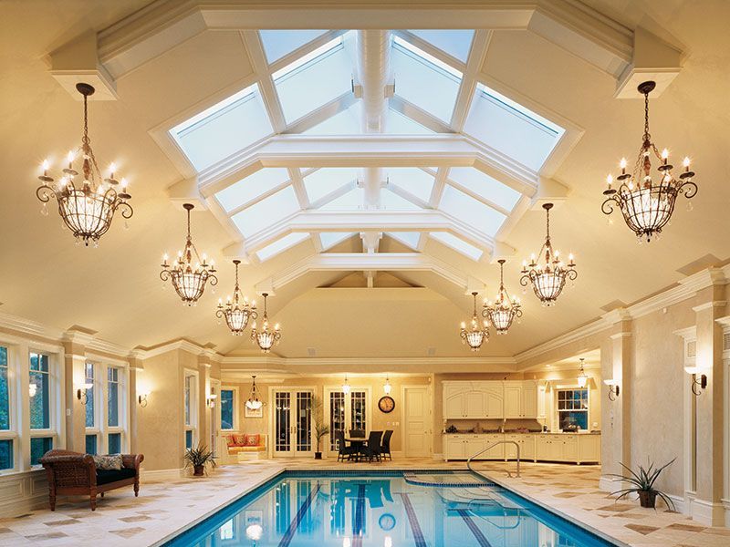 A large indoor swimming pool with a skylight above it