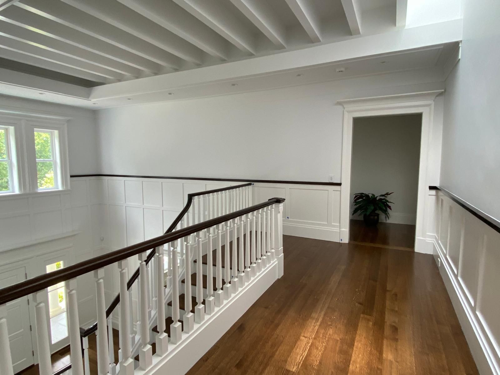 A hallway with stairs leading up to the second floor of a house.