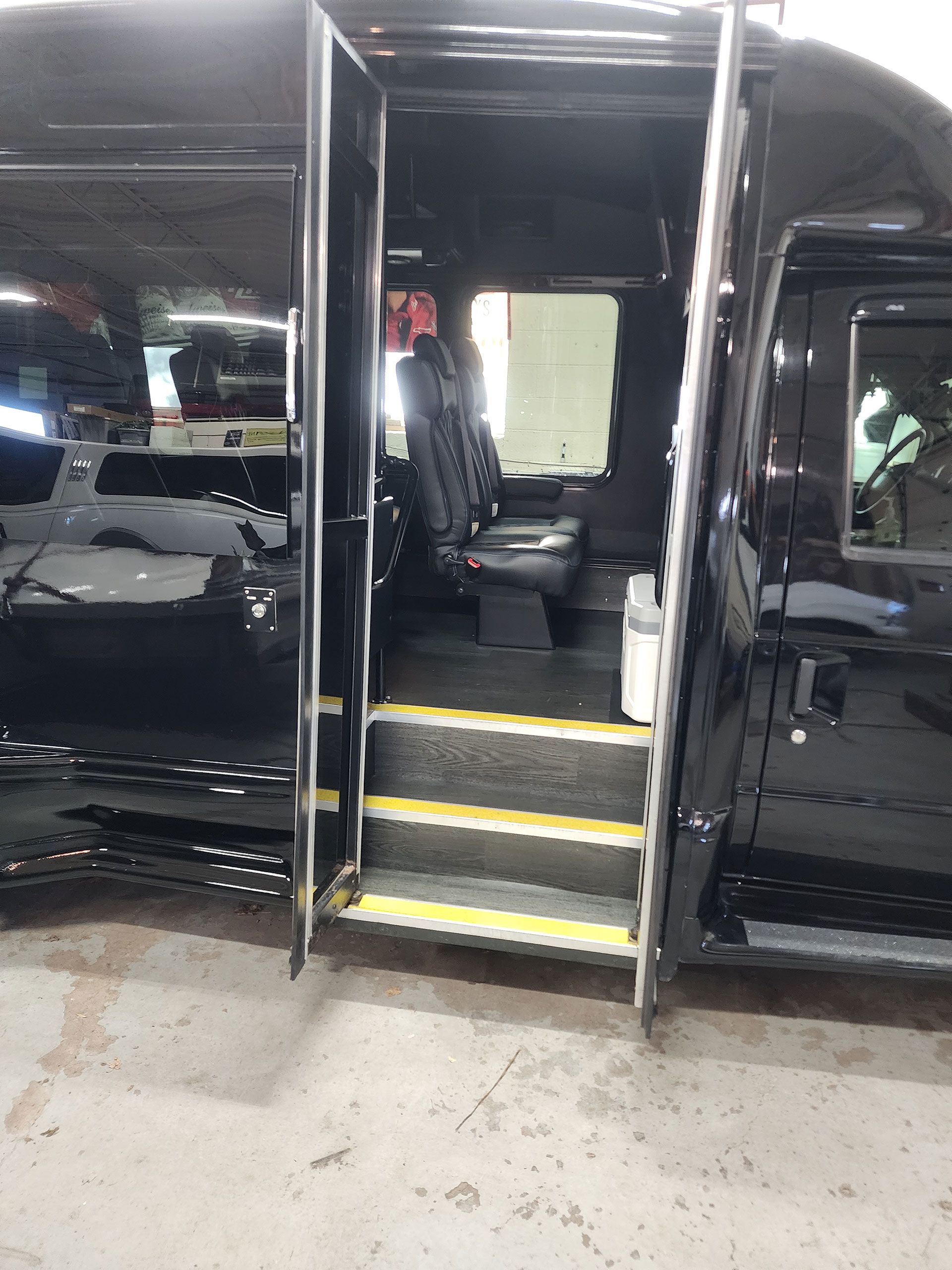Black executive bus  with stairs leading up to it