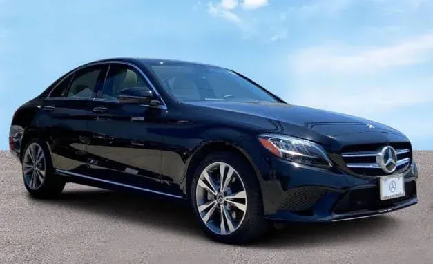 Black Mercedes-Benz C-Class sedan parked outdoors on a sunny day.