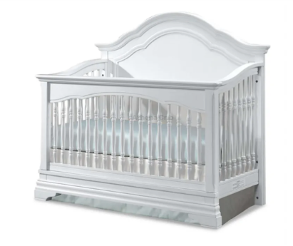 White crib with curved headboard and vertical bars.