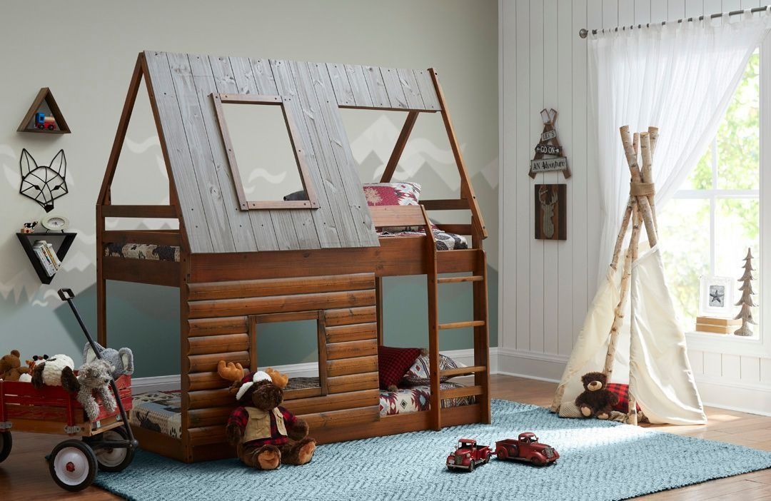 Wooden cabin-style bunk bed in a child's bedroom with a wagon, teepee, and stuffed animals.