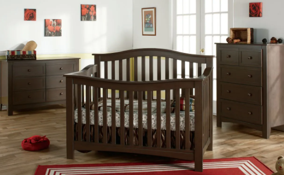 Baby nursery furniture set in dark brown: crib, dresser, and chest of drawers. Red rug and wall decor.
