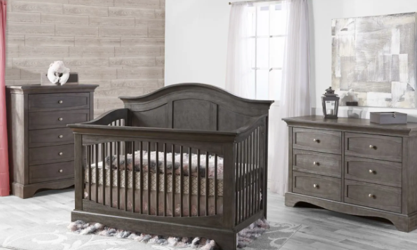 A gray wooden crib, dresser, and chest in a nursery setting with neutral decor.