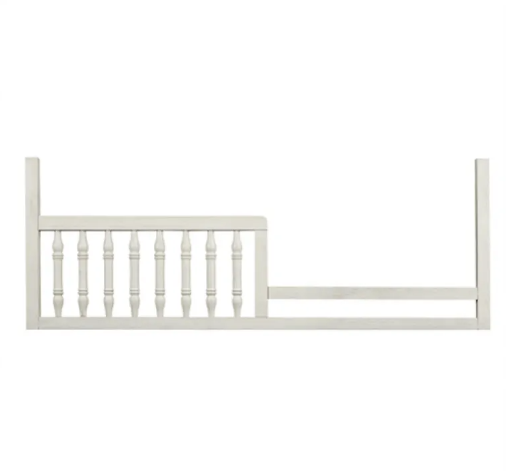 White wooden toddler bed side rail with spindles.