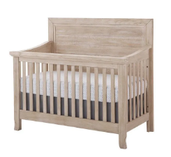 Wooden crib with a mattress. The crib is a light, natural color.
