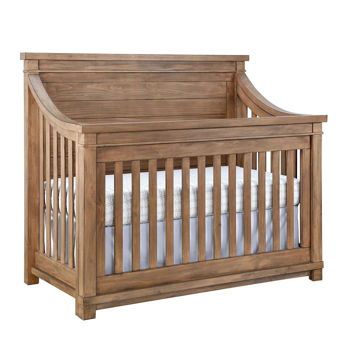 Wooden crib with a light brown finish. The mattress is white.