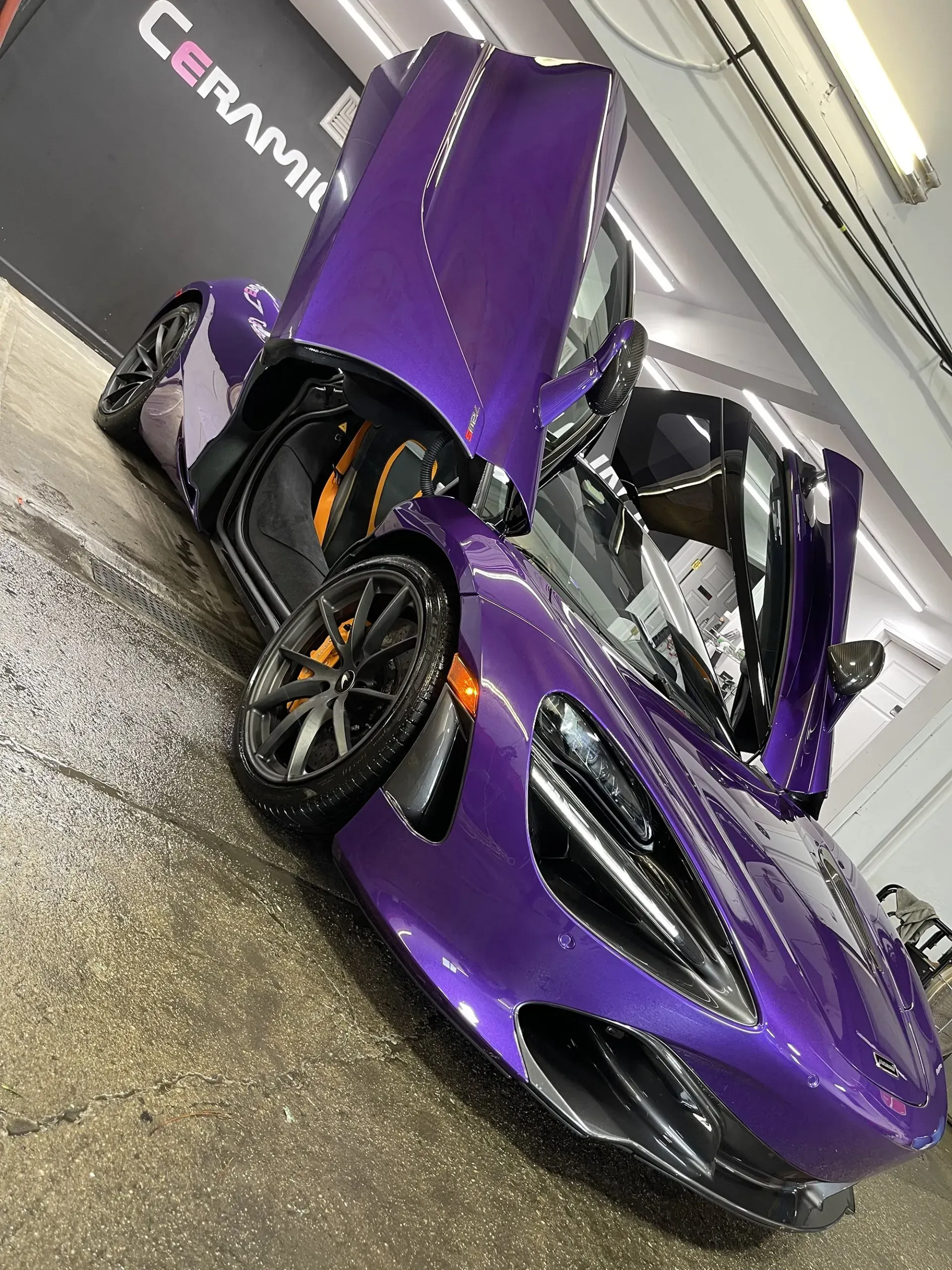Purple McLaren sports car with doors open.