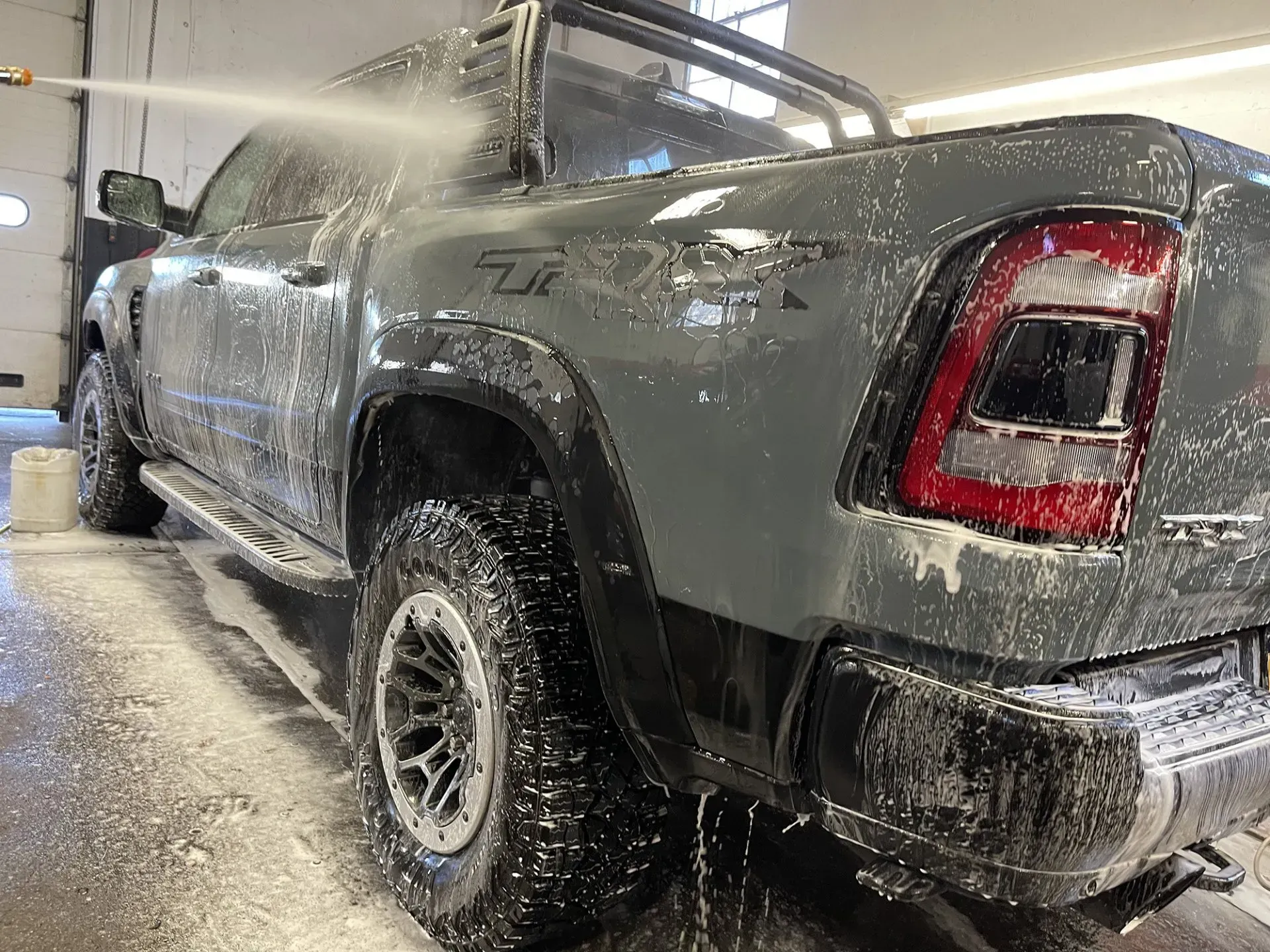 Gray RAM TRX truck being washed with foamy soap at a car wash.