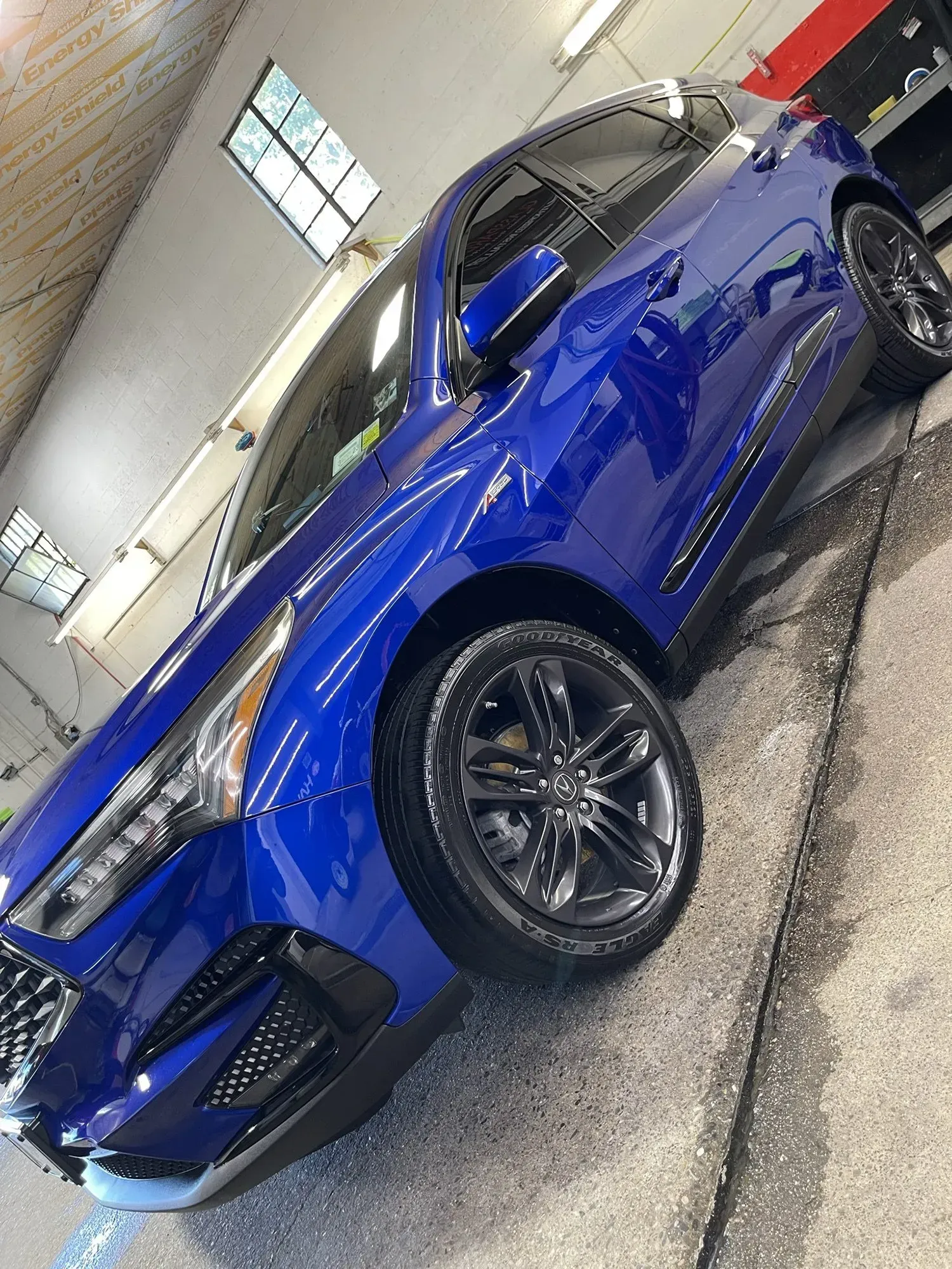 Blue Acura RDX SUV with black wheels, indoors, after a wash.
