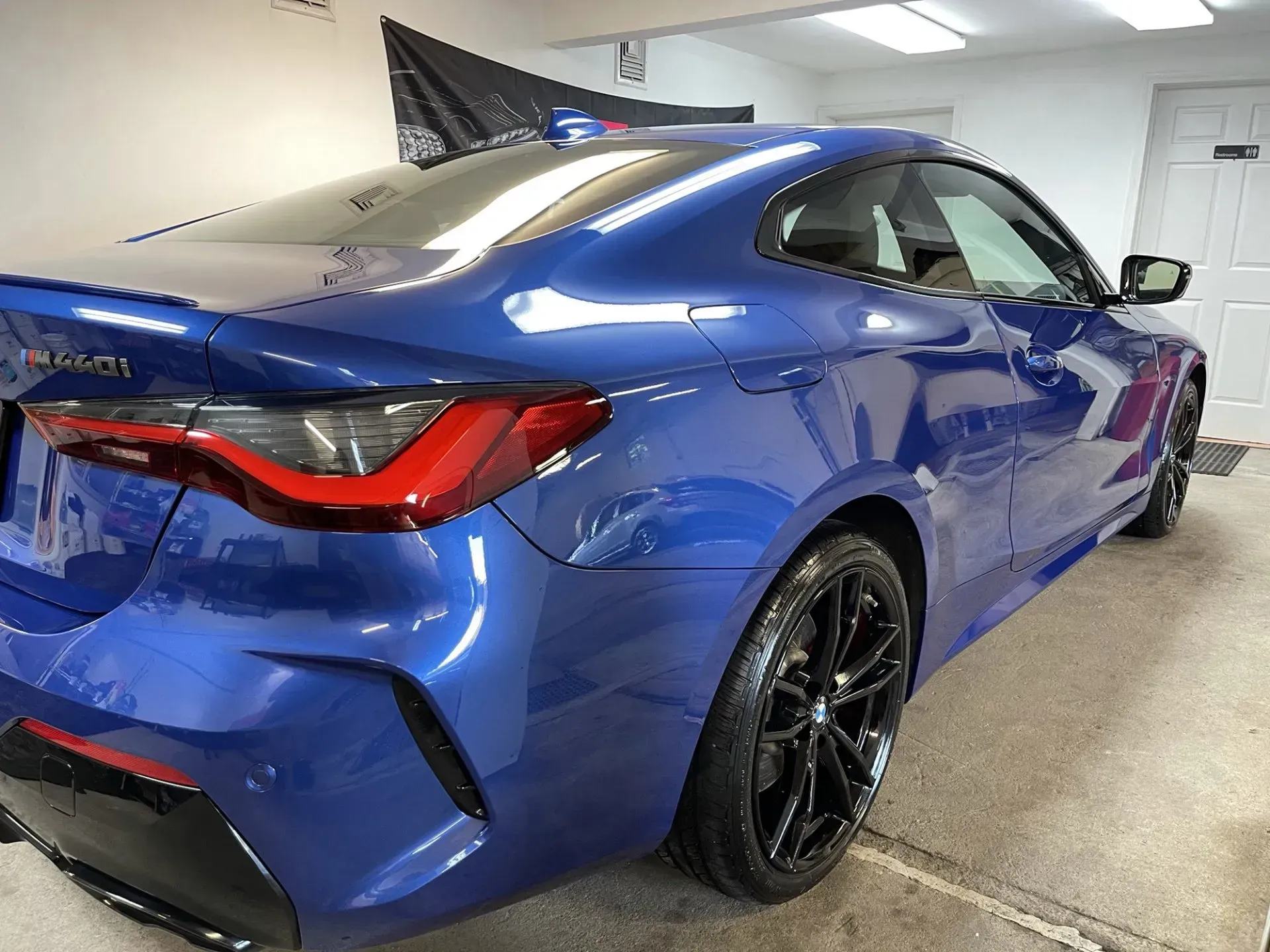Blue BMW coupe parked indoors with black rims.