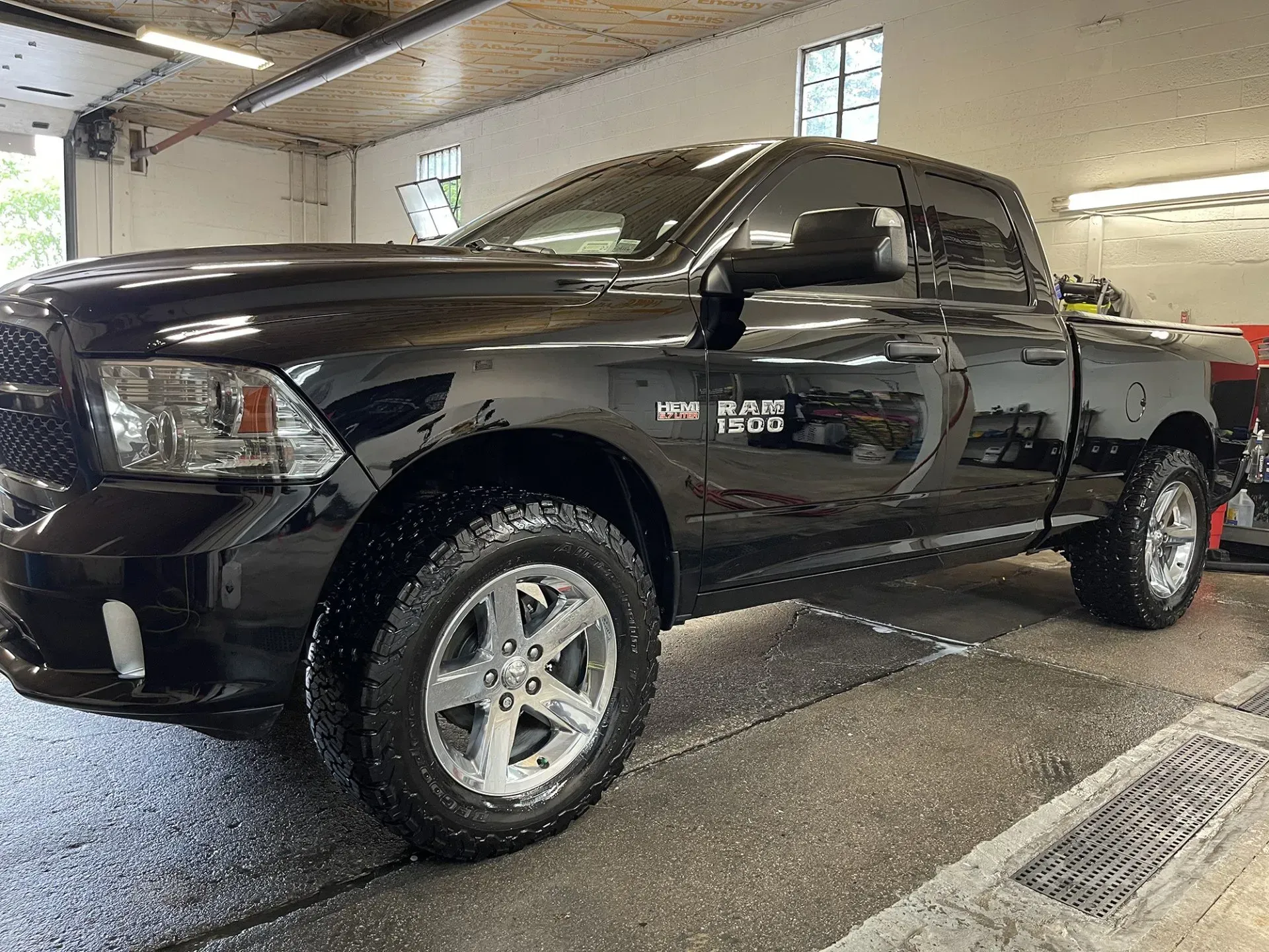 Black Dodge Ram pickup truck in a garage setting.