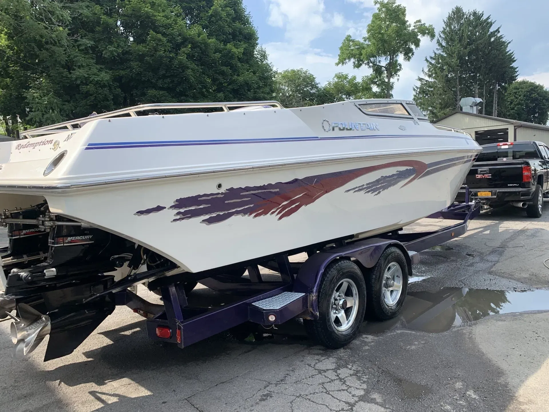White powerboat on a trailer with purple accents. Spotted in a paved lot.