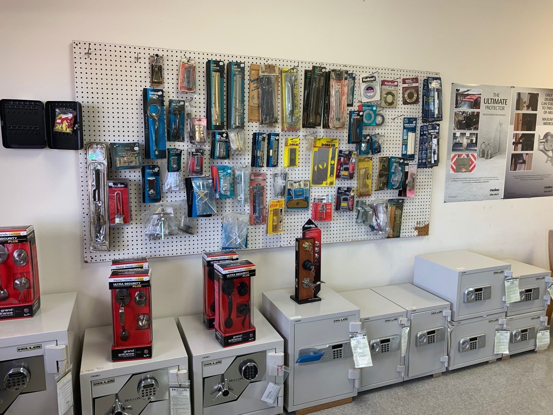 Locksmith shop interior with safes and pegboard display of keys and related items.