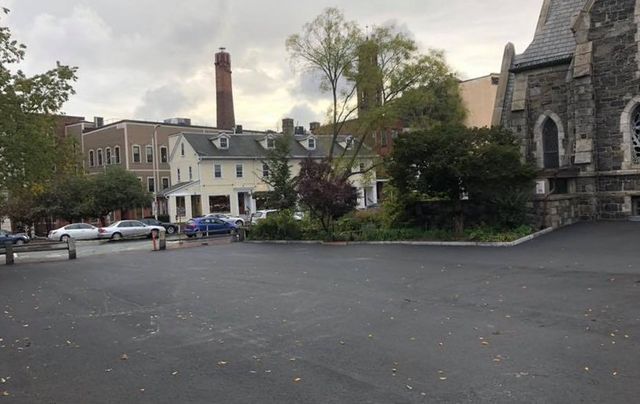 A parking lot in front of a church with cars parked in front of it.
