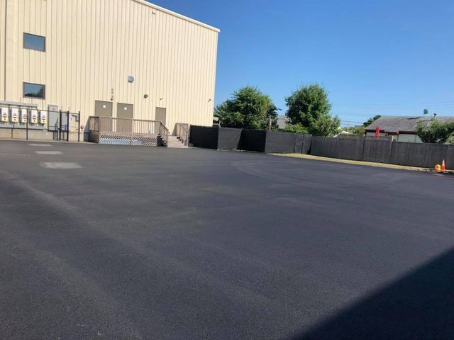 A large asphalt parking lot in front of a large building.