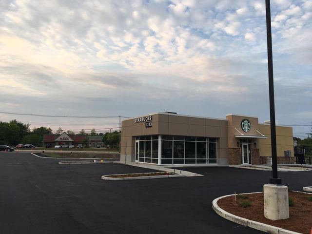 A starbucks coffee shop is being built in a parking lot.