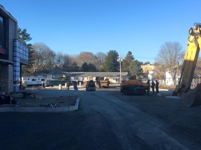 A construction site with a large yellow excavator in the middle of it.