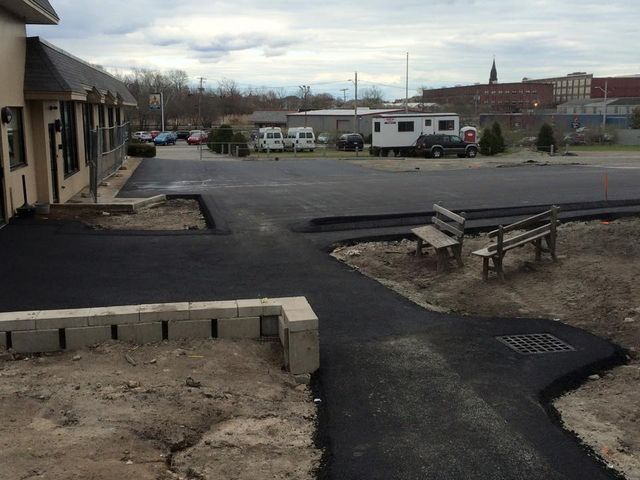 A park bench sits on the side of a road