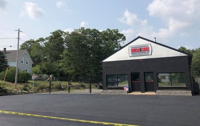 A large building with a lot of windows is sitting on top of a lush green hillside.