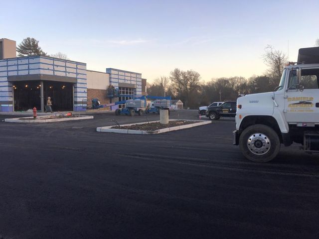 A white truck is parked in front of a building under construction.