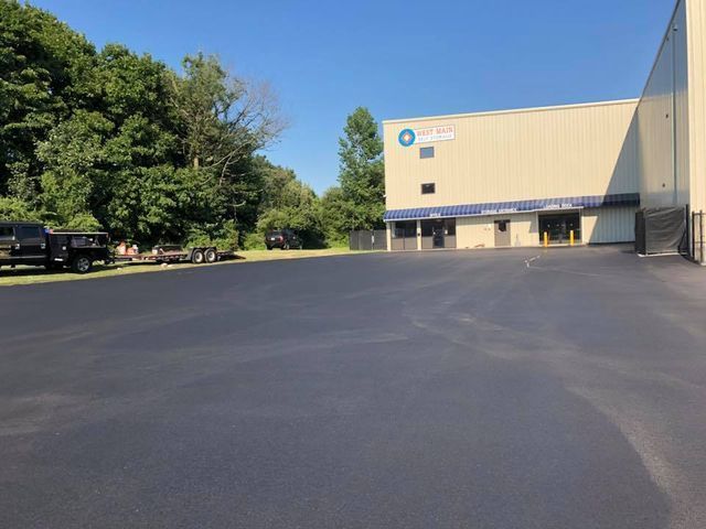 A large building with a large parking lot in front of it.